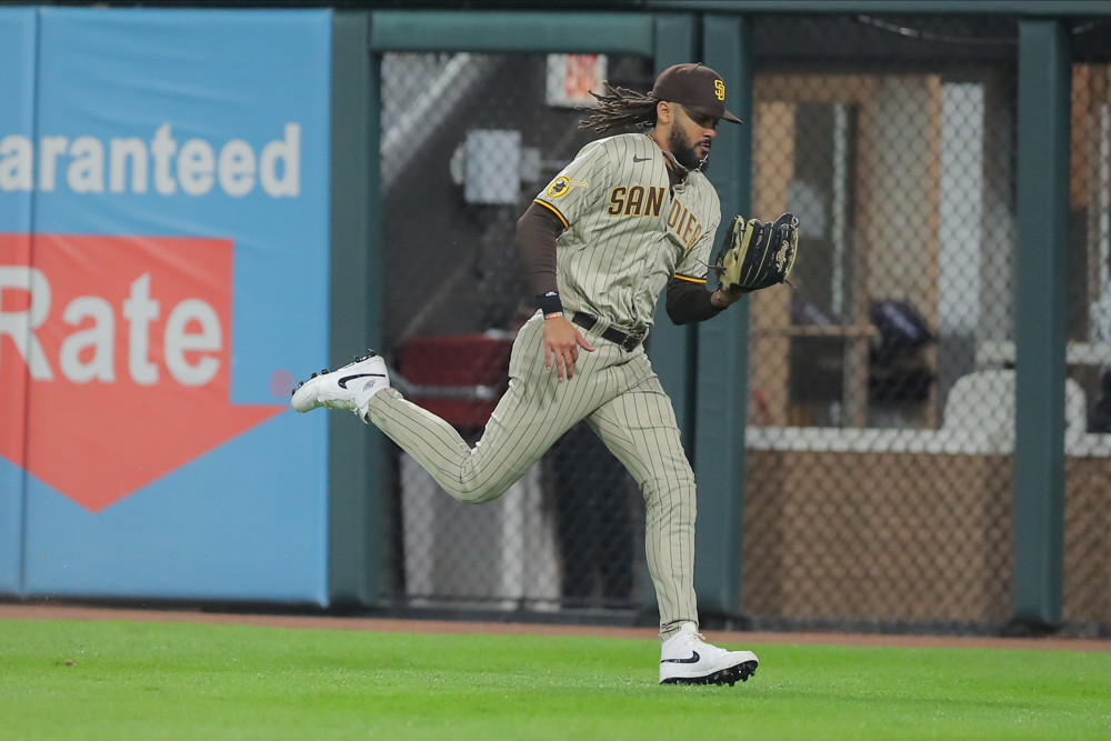Fernando Tatis Jr. makes a running catch in right field, moving back toward the fence and toward the right field line.