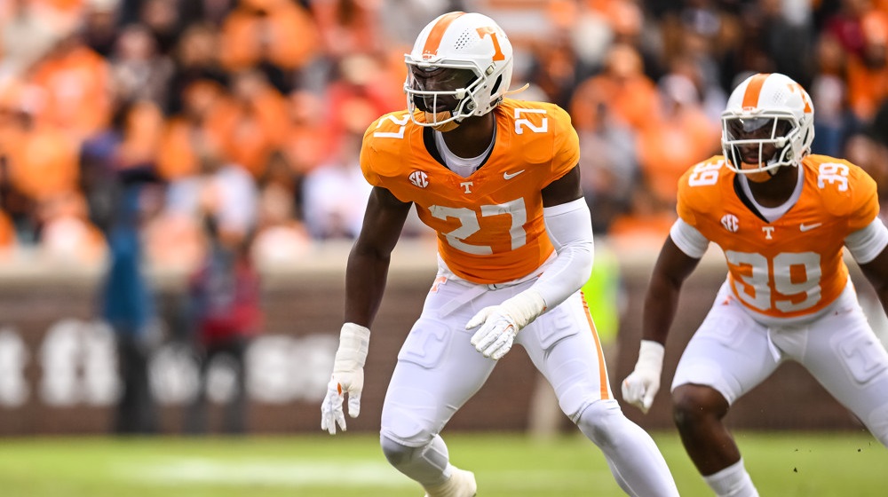 James Pearce Jr. - in orange jersey #27 and white pants with a white helmet, readies to make a play.