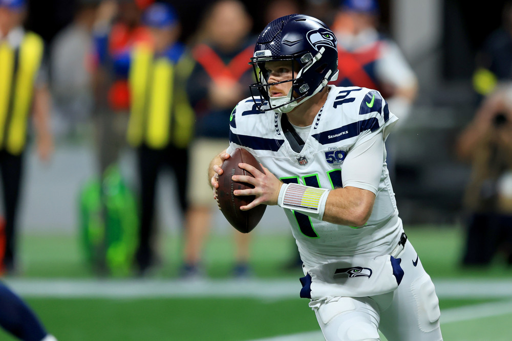 Seahawks quarterback Sam Darnold moving with the football.