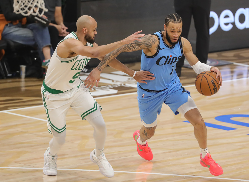 Jalen Duren, wearing a blue Pistons jersey with red No. 8, dunks with his right hand.